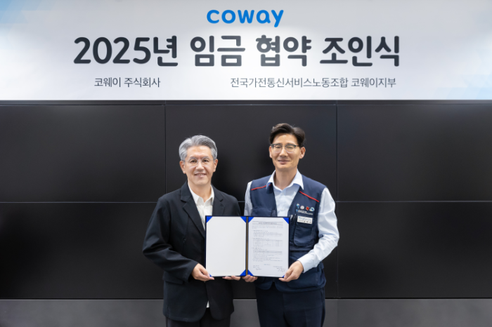 서장원 코웨이 대표이사(왼쪽)와 임창경 코웨이지부 지부장이 '2025년 임금 협약'을 체결한 뒤 기념촬영을 하고 있다.
