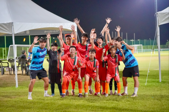 경기에서 승리한 HR풋볼클럽 U-12 6학년부 졸업생 선수들이 밝은 미소로 환호하며 단체 기념 촬영을 하고 있다./사진=HR레포츠 제공