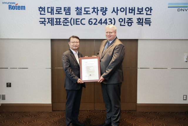 왼쪽부터 이원상 현대로템 RS기술리더와 비달 도로넨(Vidar Dolonen) DNV 명예영사가 제품 인증서를 들고 기념 촬영을 하고 있다 (이미지 제공=현대로템)