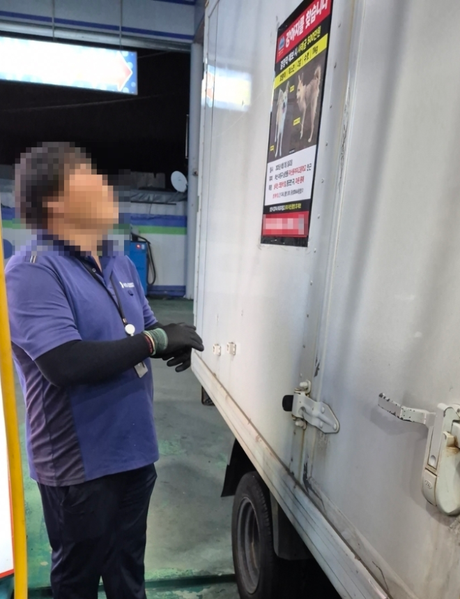 주유소 직원이 HR그룹 택배차량에 부착된 실종견 전단을 바라보고 있다. / 사진=HR그룹 미디어팀 제공