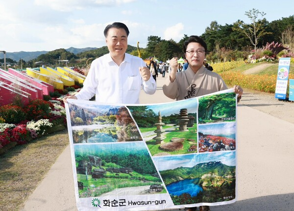 한한국 화순군 홍보대사(오른쪽)가 ‘2025 화순 고인돌 가을꽃축제장’을 찾아 구복규 화순군수와 화순의 아름다운 명소가 담긴 홍보 배너를 들고 있다. /화순군