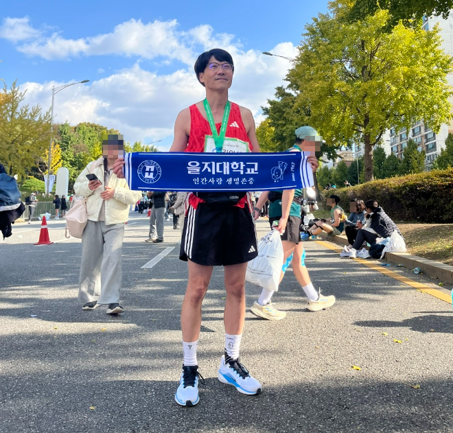 김인식 을지대학교 산학협력단장이 지난 2일 상암월드컵경기장에서 열린 JTBC 서울국제마라톤에서 풀코스 완주 후 을지대의 건학이념이 새겨진 수건을 들고 기념촬영을 하고 있다. (사진제공=을지대학교)