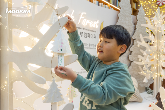 어린이 방문객이 종이 '소망 트리'에 무림의 깨끗한 종이로 제작된 페이퍼 트리 장식을 매달고 있다. /사진제공=무림페이퍼