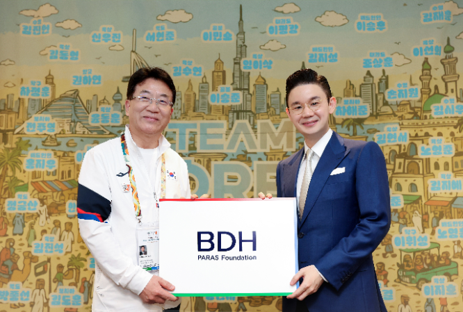 배동현 이사장(우측)이 차우규 선수단장에게 격려금을 전달한 후 기념사진을 촬영을 하고 있다.