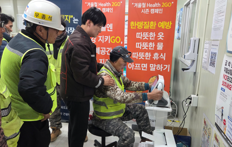 현장 근로자들이 AI기반 스마트 심전도 장비를 사용해 건강 이상징후 여부를 확인해보고 있다./한화 건설부문