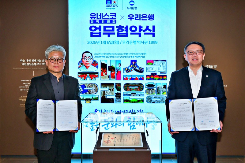 지난 6일 우리은행 역사관 ‘우리1899’에서 열린 협약식에서 우리은행 정진완 은행장과 유네스코한국위원회 윤병순 사무총장 직무대행이 대한천일은행 창립청원서 앞에서 기념촬영을 하고 있다./우리은행