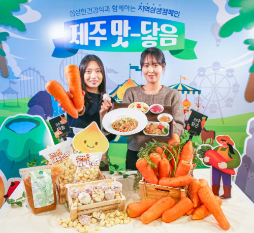 현대그린푸드 직원들이 제주산 당근과 남도종 마늘을 활용해 만든 이색 급식 메뉴인 '당근명란오일파스타'와 '마늘소스 허브닭구이'를 소개하고 있는 모습