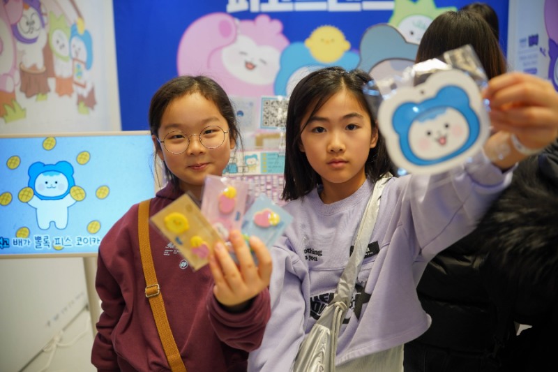 29일 서울 강남구 코엑스에서 열린 ‘K-일러스트레이션페어 서울 2026’ 코이카 피코프렌즈(PeKO Friends) 부스를 방문한 관람객이 이벤트 선물을 받고 즐거워하고 있다.