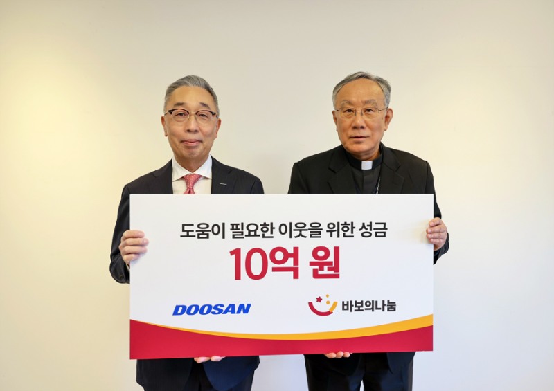 박지원 두산그룹 부회장(사진 왼쪽)과 구요비 재단법인 바보의 나눔 이사장이 3일 서울 명동성당에서 열린 성금 전달식에서 기념촬영을 하고 있다.