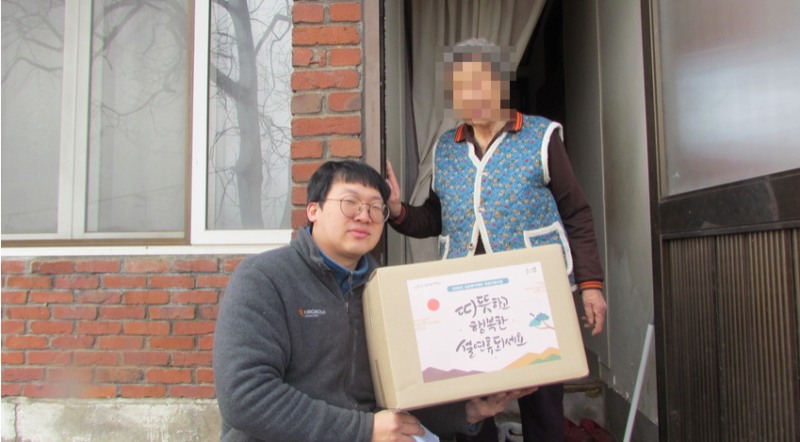 HR그룹 배송기사(왼쪽)가 설 명절 꾸러미를 김포 월곶 지역 독거 어르신(오른쪽)에게 직접 전달하며 따뜻한 인사를 건네고 있다./사진=HR그룹㈜ 미디어팀 제공