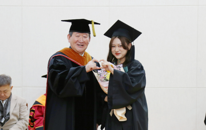 ‘2025학년도 제67회 전기 학위수여식’에서 김용승 총장과 졸업생이 함께 축하와 기쁨의 '손 하트' 연출 기념 사진 촬영을 하고 있다. (사진제공=가톨릭관동대)