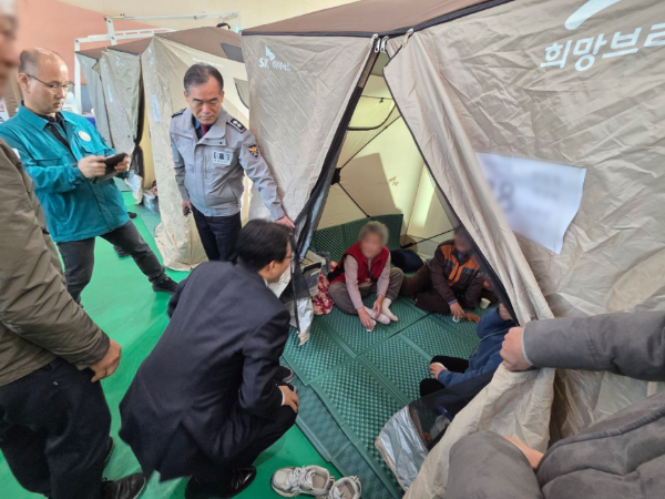 김민석 국무총리가 23일 새벽 경남 함양 산불 대피소를 방문해 희망브리지가 긴급 지원한 임시 주거용 칸막이 내에서 이재민들을 위로하고 있다. (사진제공 = 국무총리실)