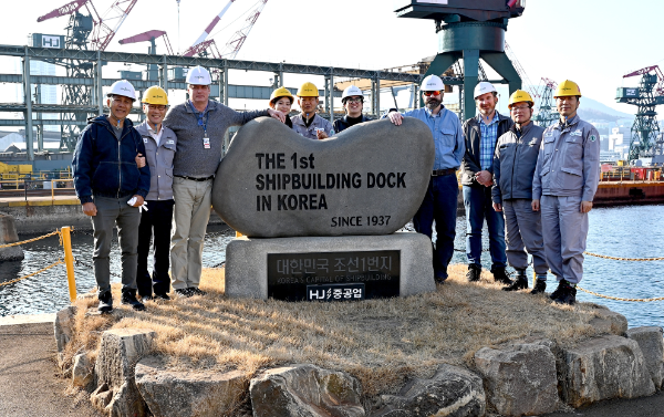 유상철 HJ중공업 대표(왼쪽에서 두 번째) 등 회사 관계자들이 2026년 2월 12일 HJ중공업이 진행하고 있는 MRO 사업 점검을 위해 부산 영도조선소를 방문한 짐 굿하트 MSC 부국장 등 미국 해군 관계자들과 기념촬영을 하고 있다. 사진= HJ중공업