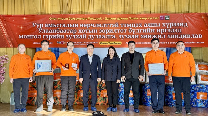 국제위러브유 몽골 지부장들이 몽골 울란바토르 관계자로부터 받은 상패를 들고 활짝 웃고 있다. 뒤에 보이는 물품은 기후위기 취약계층의 주거 환경을 개선하기 위해 마련한 게르 단열 덮개와 겨울이불.