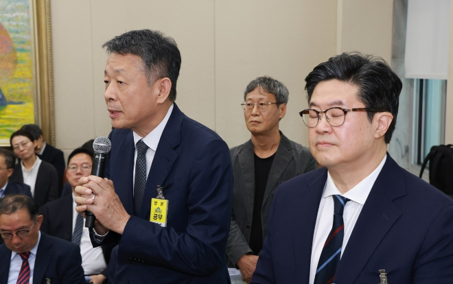 김광일 홈플러스 대표이사(MBK파트너스 부회장, 왼쪽)가 2025년 10월 14일 서울 여의도 국회에서 열린 공정거래위원회, 개인정보보호위원회 등에 대한 정무위원회 국정감사에 증인으로 출석, 의원 질의에 답변하고 있다. 그 옆에 김병주 MBK 회장이 눈을 감고 서 있다. 사진= 연합뉴스