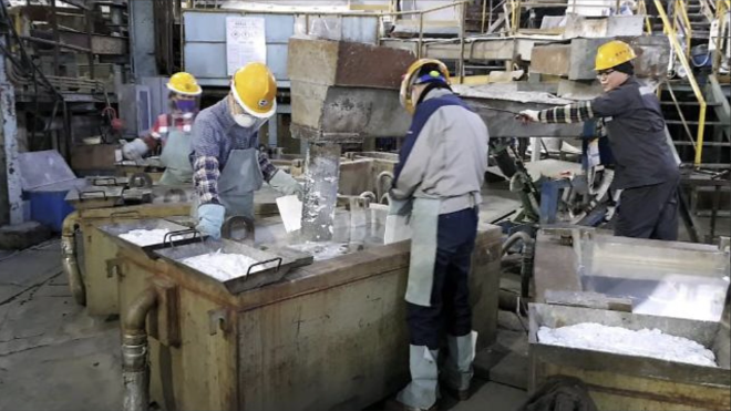 영풍 석포제련소 주조공장에서 직원들이 주조기에 담겨 고체로 굳어지고 있는 액체 상태의 아연의 표면을 철판으로 반질하게 다듬고 있다. 석포제련소는 환경문제로 시민단체로부터 폐쇄 요구에 시달리고 있다. 사진= 채명석 기자