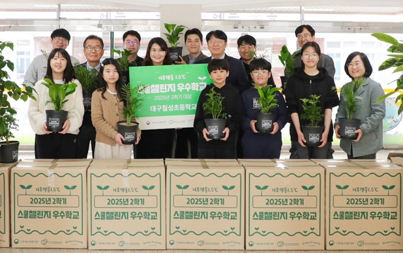 지난 9일 더현대 대구 임직원들이 기후에너지환경부 탄소중립 프로그램 '기후행동 1.5℃ 스쿨챌린지'에서 초등학교 부문 대상을 받은 대구 칠성초등학교를 방문해 공기정화식물을 전달하고 학생 및 교사들과 기념사진을 찍고 있다.