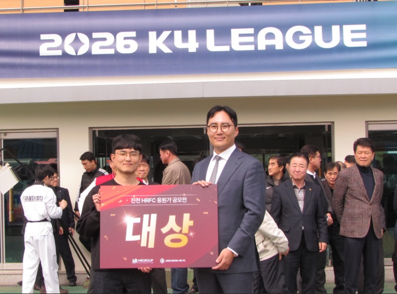 진천 HR FC 응원가 공모전 대상 수상자 신승우 씨(왼쪽)가 신호룡 진천 HR FC 구단주(오른쪽)와 함께 기념 촬영을 하고 있다./HR레포츠㈜ 미디어팀 제공