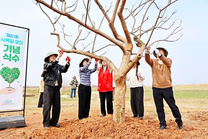 하림 임직원 및 행사 참여자들이 새만금환경생태단지에 나무를 식재한 후, 친환경 소재를 활용해 제작한 수목 이름표를 나무에 직접 걸어주는 체험 활동을 하고 있다.
