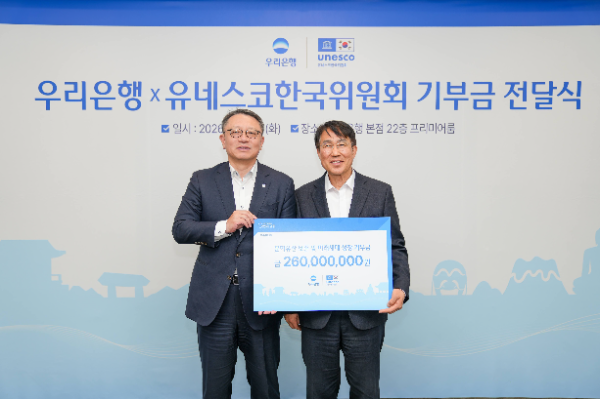 홍현익 유네스코한국위원회 사무총장(오른쪽)에게 기부금을 전달하는 정진완 우리은행장 (사진제공=유네스코한국위원회)