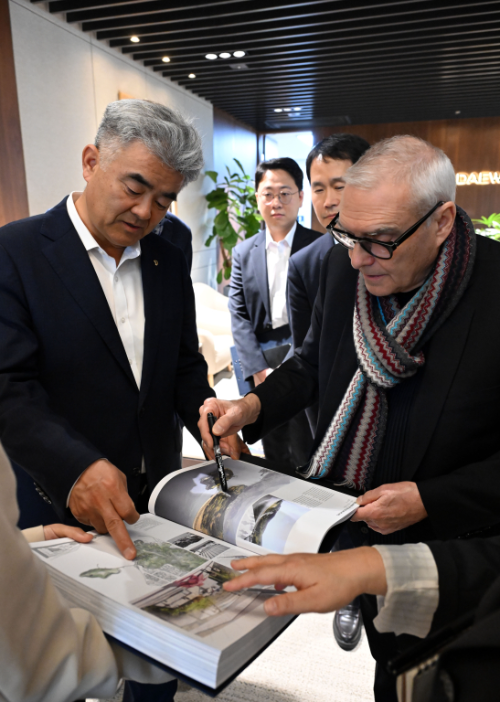 도미니크 페로가 본인의 작품집을 대우건설 정원주 회장에게 설명하고 있다./대우건설