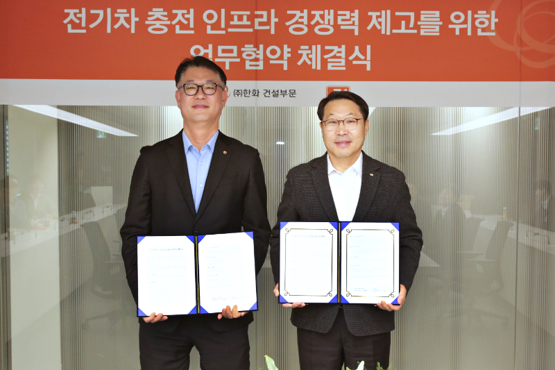 한화 건설부문 김민석 건축사업본부장(좌측)과 E1 김수근 영업본부장(우측)이 전기차 충전기 공급 및 운영을 위한 전략적 파트너십 체결하고 기념촬영을 하고 있다./한화 건설부문