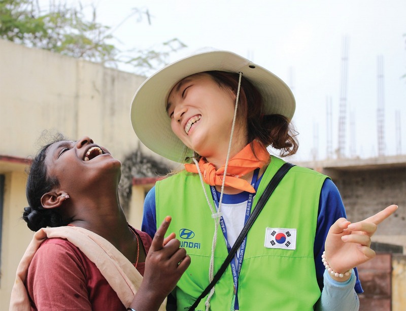 해피무브 봉사단에 참여한 자원봉사자가 현지 여성과 대화를 나누며 환하게 웃고 있다./현대자동차그룹