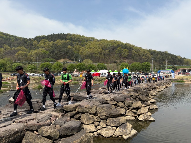 진천 농다리에서 열린 ‘2026 레이크 사랑 걷기 대회’에서 진천 HR FC 선수단이 플로깅 활동을 하며 돌다리를 건너고 있다./사진=HR레포츠㈜ 제공