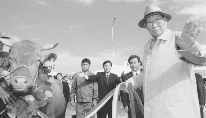 정주영 현대그룹 명예회장이 1998년 6월 16일 1차 소때 방북 직접 키운 소 500마리를 북측에 보내기에 앞서 소고삐를 잡고 환송 인파에게 인사를 건네고 있다. 사진= HMM 50년사