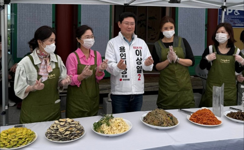 이상일 국민의힘 용인시장 후보가 26일 '2026 봄나물 축제’행사장에서 참석자들과 기념촬영을 하고있다./페이스북 캡처