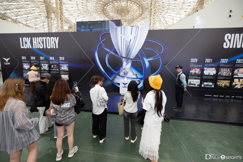 LCK 로드쇼를 방문한 베트남 팬들이 LCK 우승 트로피를 보고 있다.