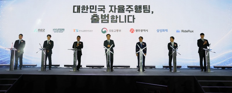 업무협약식에 참석한 주요 인사들이 전자 서명판에 서명을 위해 연단에 서 있다. (왼쪽부터) 오토노머스 A2Z 한지형 대표, 현대차·기아 박민우 AVP본부장(사장), 한국교통안전공단 정용식 이사장, 국토교통부 김윤덕 장관, 광주광역시 강기정 시장, 삼성화재 이문화 사장, 라이드플럭스 박중희 대표/현대차그룹