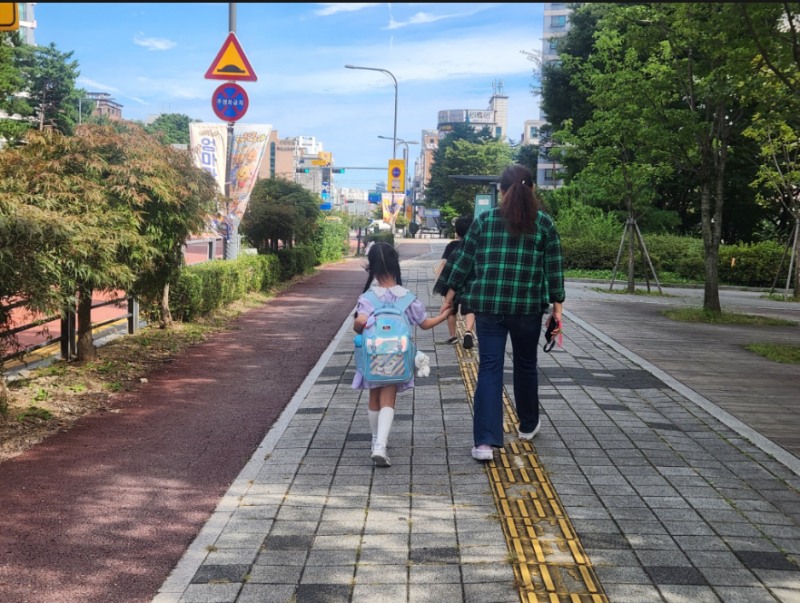 ‘초등 저학년 등하교 동행돌봄 서비스’로 아이와 동행하고 있는 새빛돌보미. /수원시