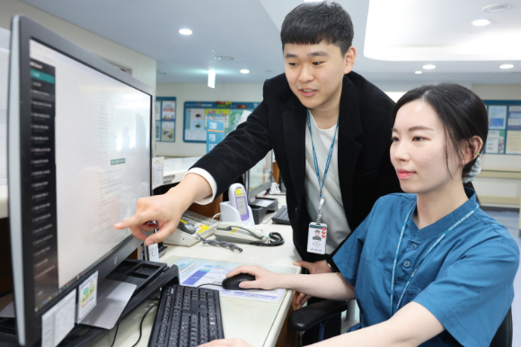 서울아산병원 임언석 IT전략팀 주임(왼쪽)이 여건영 간호교육행정팀 대리에게 프라이빗 AI 지식 검색 시스템 활용법에 대해 설명하고 있다. <사진=서울아산병원 제공>