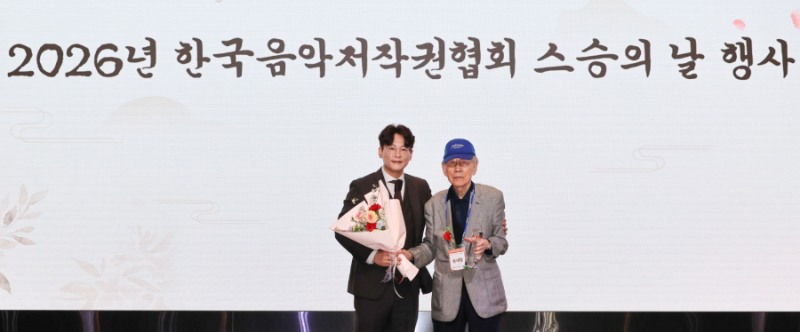 (▲이시하 음저협 회장(사진 왼쪽)이 송재철 회원(오른쪽)에게 감사패와 꽃다발을 전달한 뒤 기념촬영을 하고 있다)