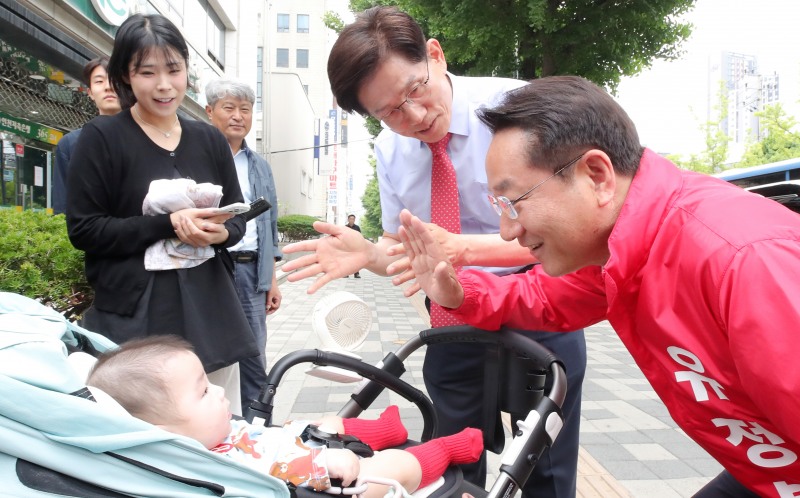 유정복 인천시장 후보와 김문수 명예선대위원장이 19일 석바위시장에서 한 아기와 눈 인사를 하고 있다./정복캠프