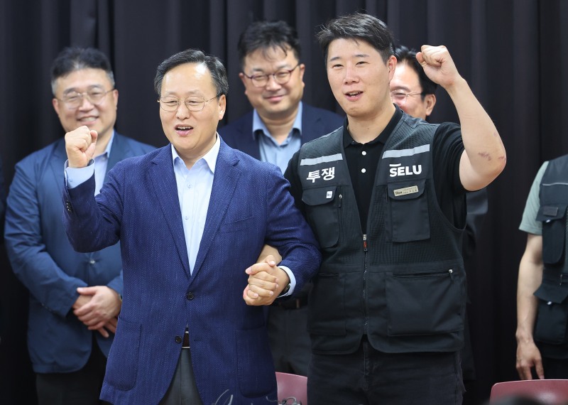 20일 경기도 수원시 장안구 경기고용노동청에서 열린 삼성전자 임금협상을 마친 후 여명구 삼성전자 DS(디바이스솔루션·반도체 사업 담당) 피플팀장과 최승호 삼성그룹 초기업노동조합 삼성전자지부 위원장이 잠정 합의안에 서명한 후 파이팅을 외치고 있다./연합뉴스