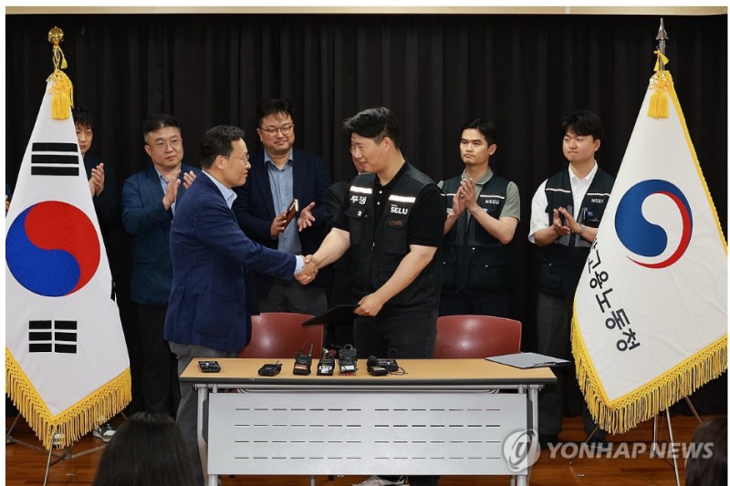 20일 경기도 수원시 장안구 경기고용노동청에서 열린 삼성전자 임금협상을 마친 후 여명구 삼성전자 DS(디바이스솔루션·반도체 사업 담당) 피플팀장과 최승호 삼성그룹 초기업노동조합 삼성전자지부 위원장이 잠정 합의안에 서명한 후 손을 맞잡고 있다. 사진=공동취재