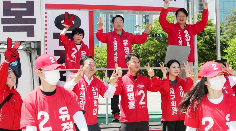 유정복 인천시장 후보가 22일 서구 청라 일대 유세 현장에서 선거운동원 및 지지자들과 함께 기호 2번 손동작을 하며 지지를 호소하고 있다./정복캠프