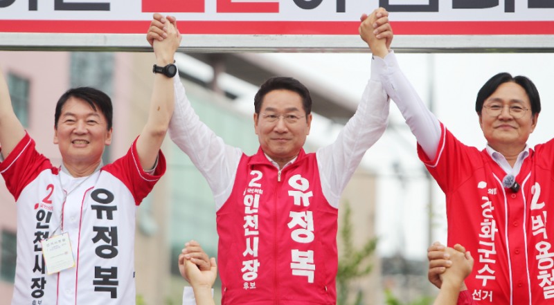 유정복 인천시장 후보가 27일 강화군 풍물시장 유세 현장에서 국민의힘 안철수 의원, 박용철 강화군수 후보와 손을 맞잡고 지지자들에게 인사하고 있다./정복캠프
