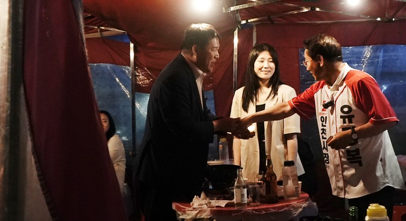 지난 30일 새벽 유정복 인천시장 후보가 남동구 구월동 로데오거리의 한 포장마차를 방문해 시민과 악수하며 인사를 나누고 있다. /정복캠프
