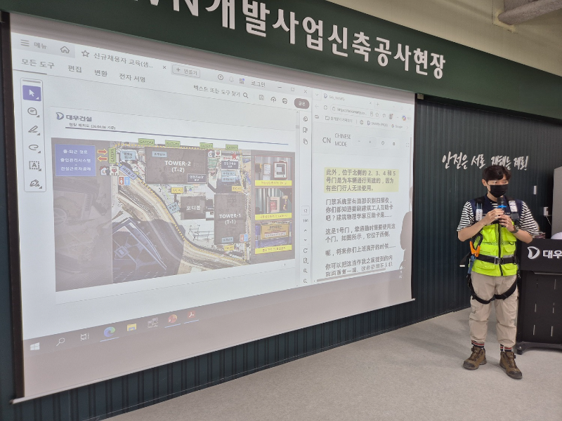 대우건설 관계자가 과천 G-TOWN 개발사업 신축공사 현장에서 외국인 근로자를 위한 AI 번역기 기능에 대해 교육 중이다./대우건설