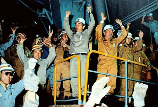 포항제철 임직원들이 1973년 6월 9일 7시 30분 포항 1고로의 역사적인 고로의 첫 출선을 기뻐하며 만세를 외치고 있다. 그러나 함께 자리한 박태준 사장(가운데)의 얼굴은 그다지 밝아 보이지 않는다. 사진= 포스코