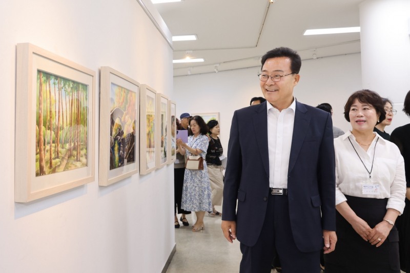 김성제 의왕시장이 제14회 백운미술인회전’ 개전식에 참석한뒤 작품을 둘러보고있다. /의왕시