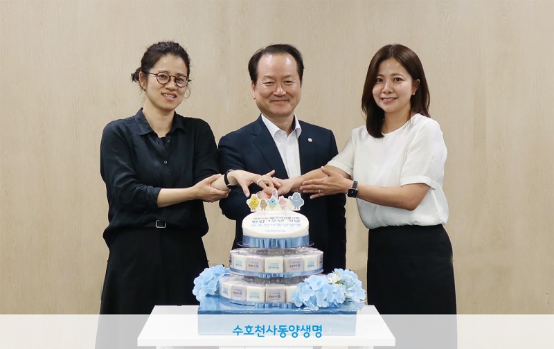 동양생명 성대규 대표이사(가운데)가 지난 7월 1일 열린 ‘돌잡이’ 콘셉트의 타운홀 미팅에서 직원들과 함께 기념 떡을 자르고 있다./동양생명
