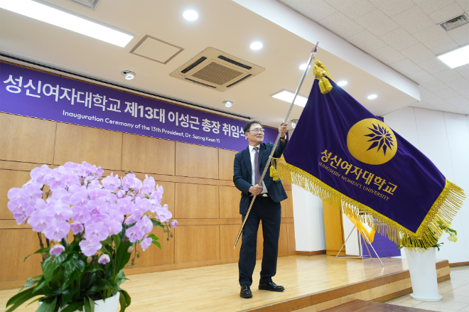 성신여대 제13대 총장 취임식에서 학교기를 전달받은 이성근 총장이 힘차게 교기를 흔들고 있다. (사진제공=성신여대)