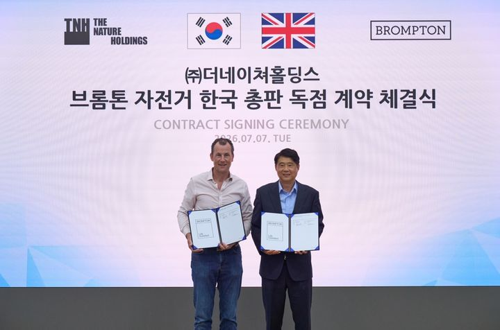 더네이쳐홀딩스가 브롬톤(BROMPTON)과 자전거 한국 총판 계약을 체결했다. 윌 버틀러-아담스 대표(왼쪽)와 박영준 더네이쳐홀딩스 대표(오른쪽)가 기념사진을 촬영하고 있다./더네이쳐홀딩스