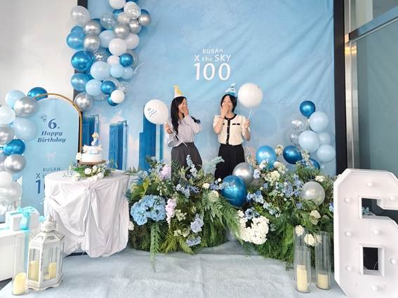 전망대 100층에 마련된 개관 6주년 기념 생일 콘셉트 포토존에서 관람객들이 기념사진을 촬영하고 있다.