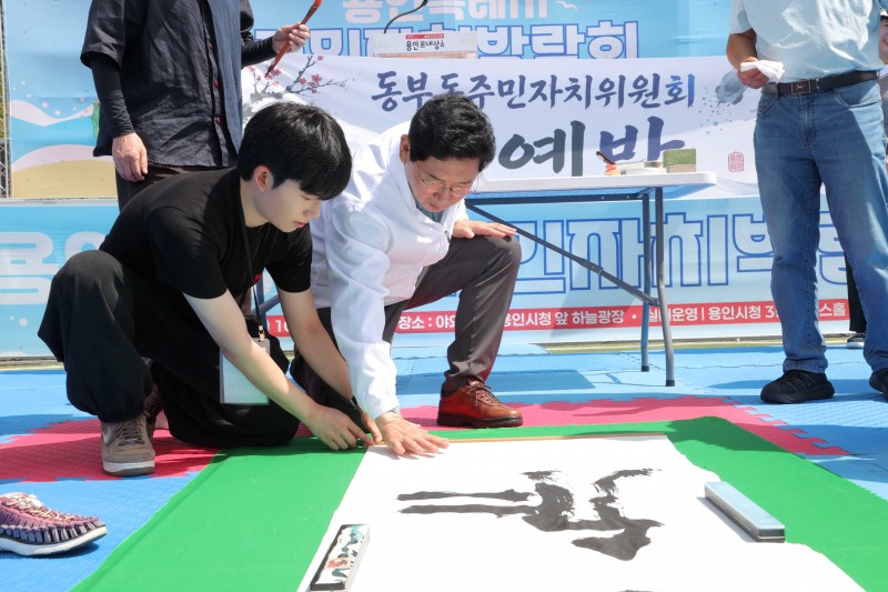 이상일 용인특례시장이 11일 용인특례시 주민자치박람회에서 서예 작품에 손도장을 찍고 있다. /용인시