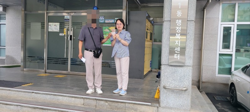 지난달 수원시 한 동행정복지센터에서 주민등록증을 발급받은 강모씨가 김경숙 베테랑팀장과 주민등록증을 들고 있다. /수원시
